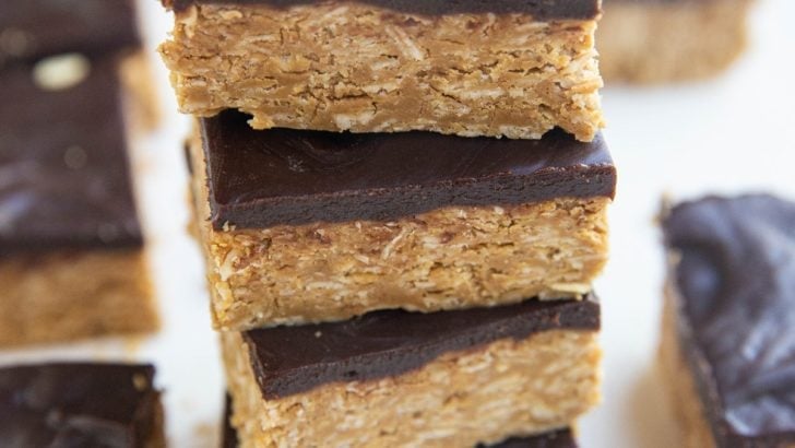 Stack of peanut butter oatmeal bars with a layer of chocoalte on top.