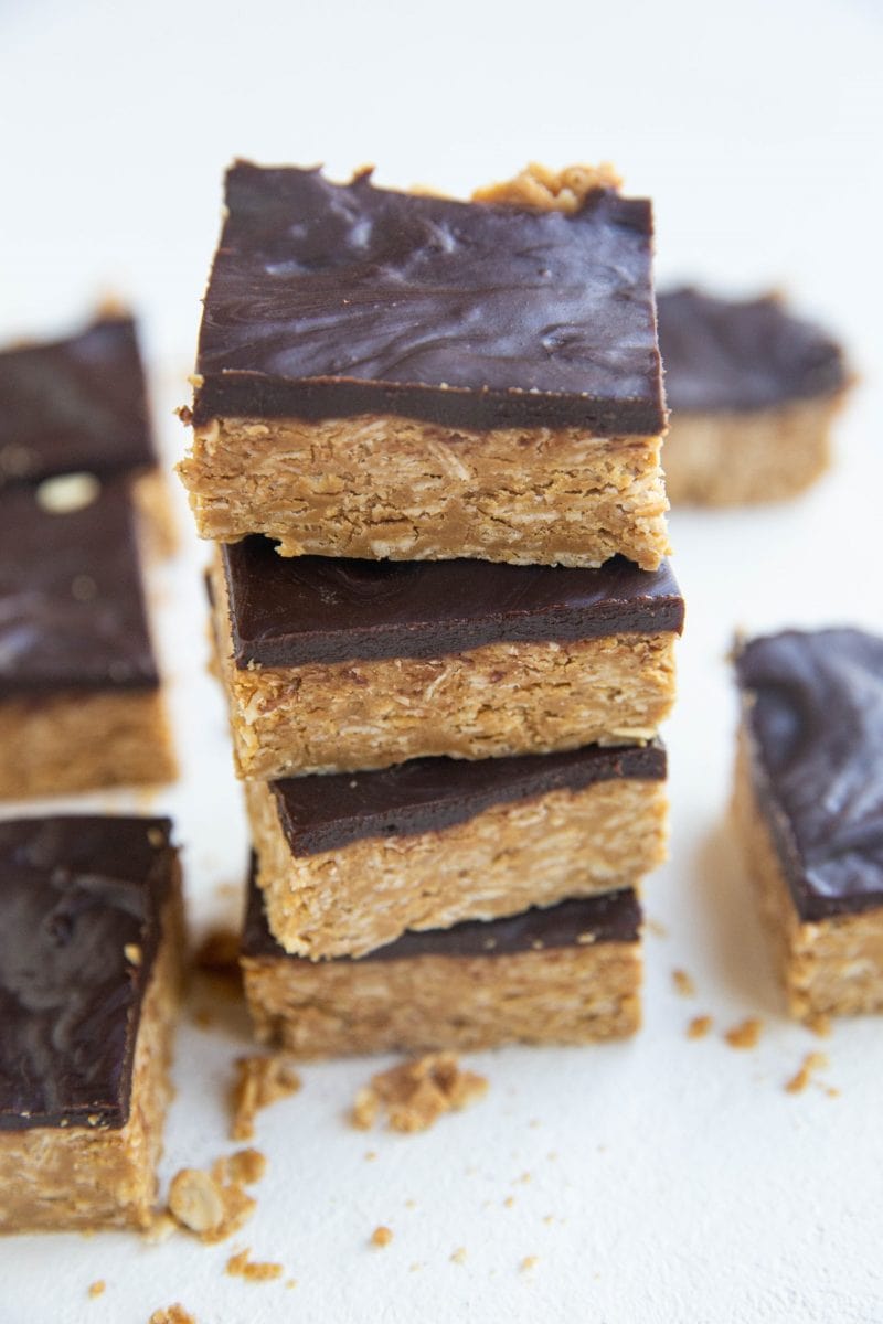 Stack of peanut butter oatmeal bars with a layer of chocoalte on top.