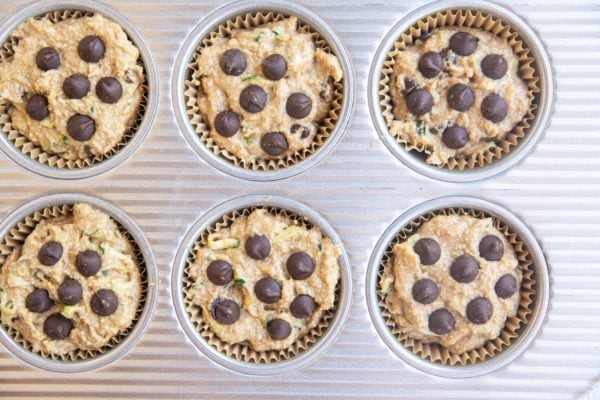 Muffin pan with zucchini muffin batter ready to go into the oven.