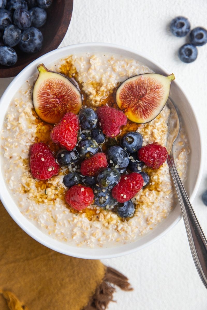 top down photo of steel cut oats with berries and figs on top.