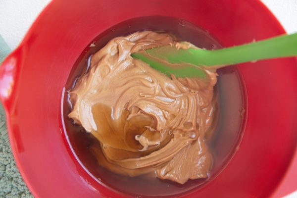 Wet ingredients for bars in a red mixing bowl.