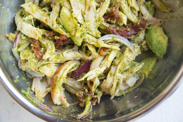 Pesto chicken salad mixed up in a bowl.