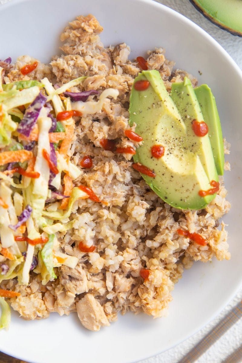 Salmon and rice with avocado and coleslaw in a bowl.