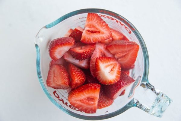 Fresh strawberries in a measuring cup
