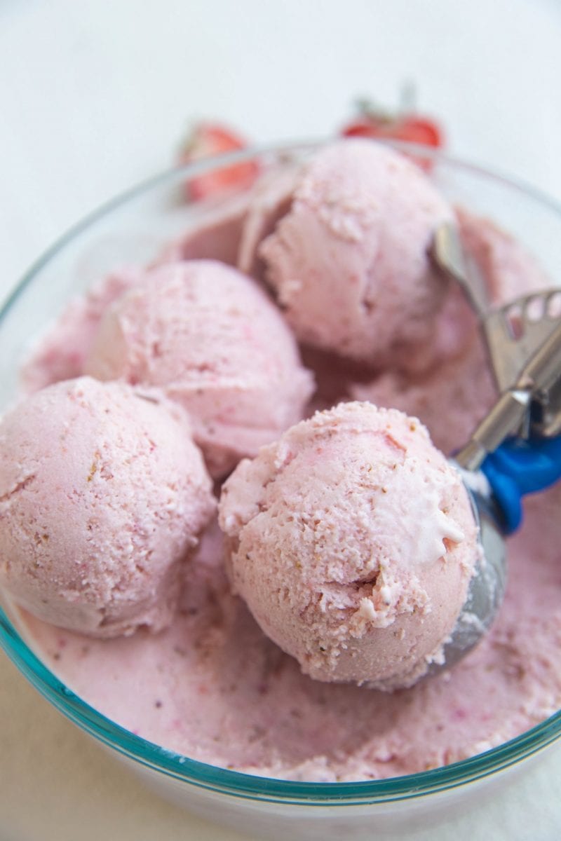 Scoops of strawberry ice cream in the container housing the ice cream