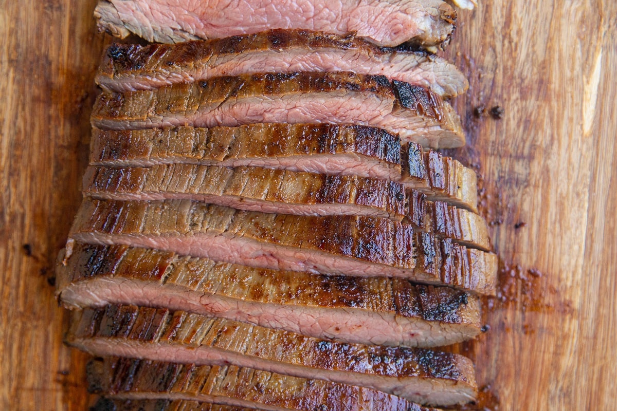 Sliced skirt steak on a cutting board.