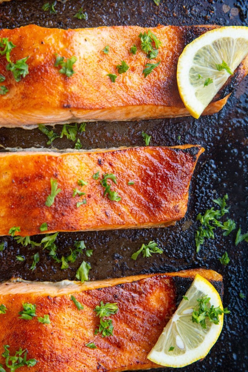 Baking sheet of finished broiled salmon fresh out of the oven.