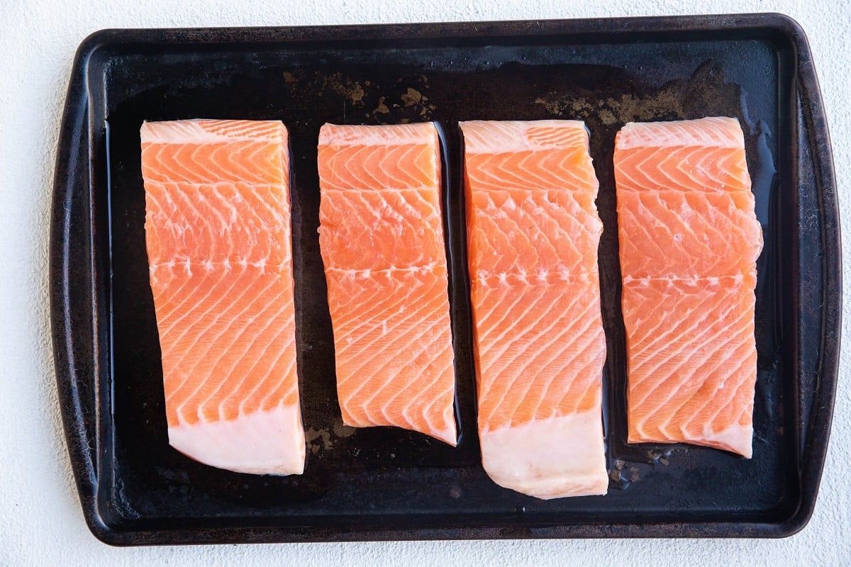 Salmon filets on a rimmed baking sheet for broiling.