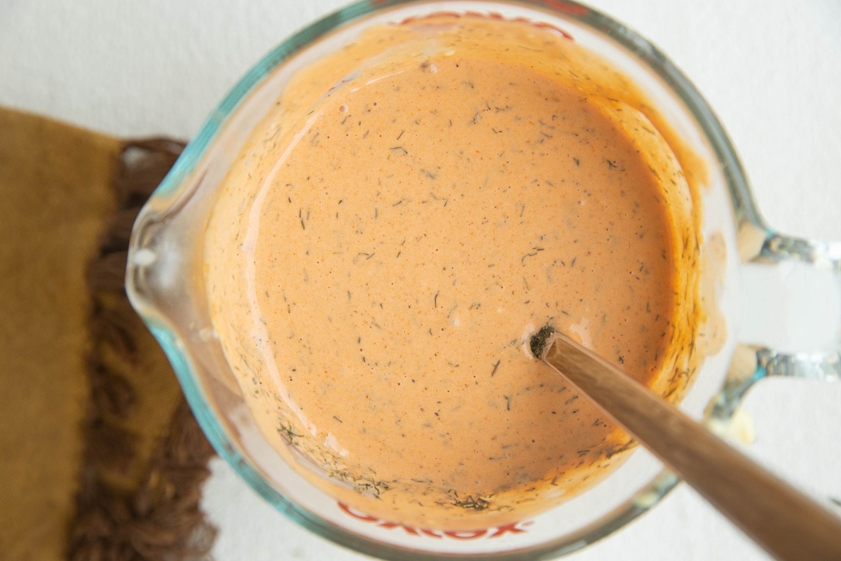 Sauce for buffalo chicken dip stirred up in a measuring cup.