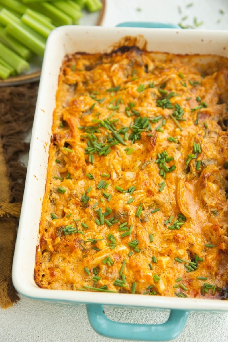 casserole dish with buffalo chicken dip and celery sticks in the background