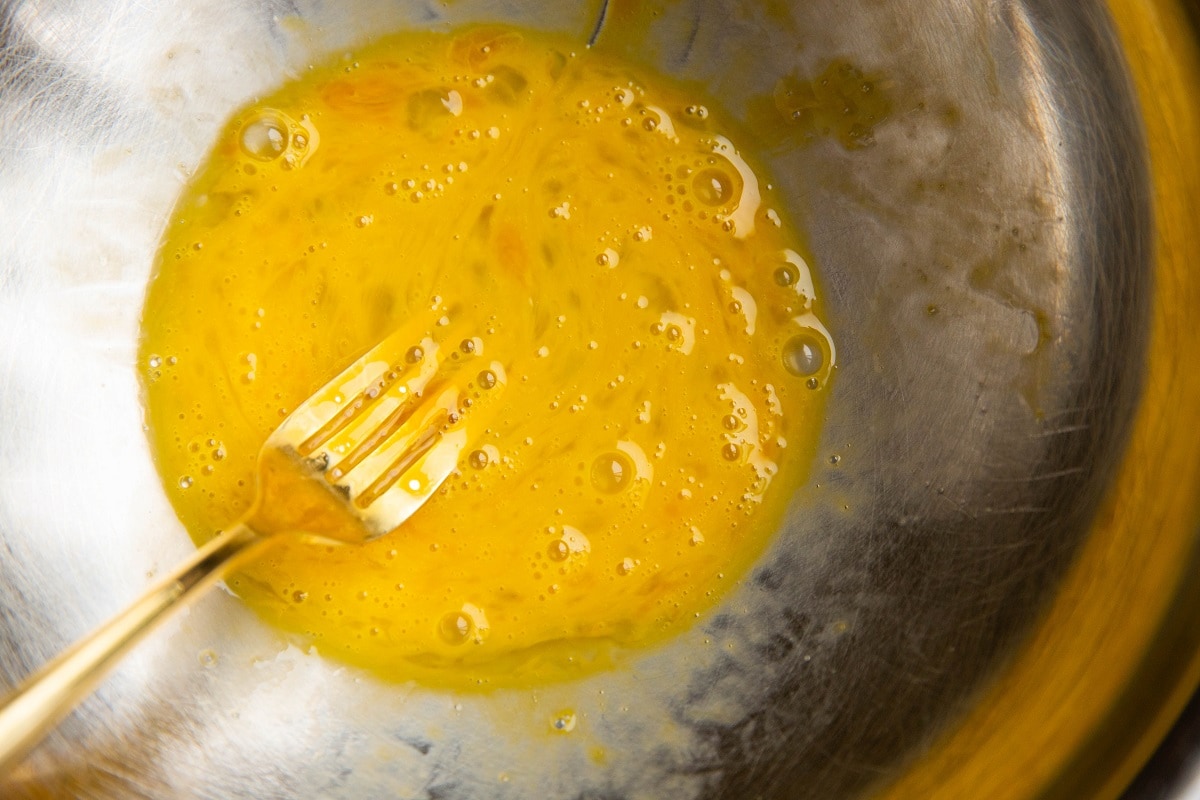 Whisked egg in a mixing bowl for coating beef