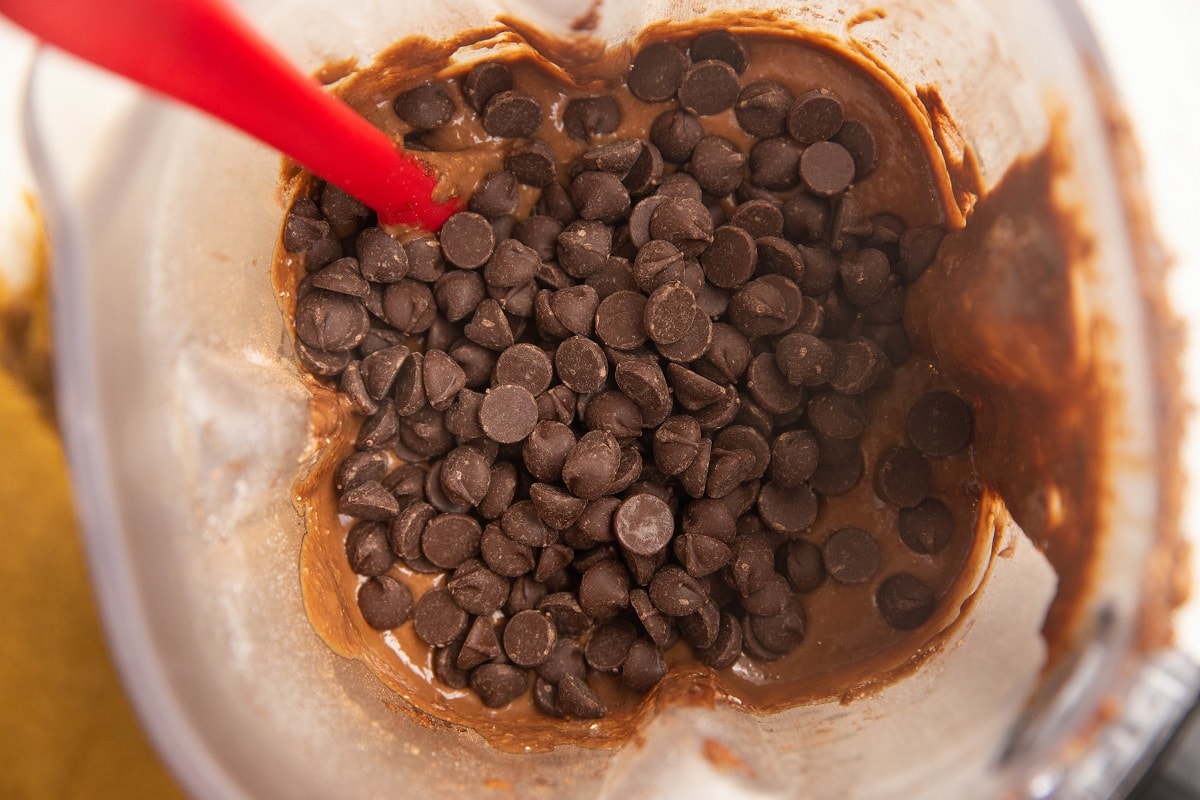 Chocolate banana bread batter with chocolate chips on top, ready to be stirred in