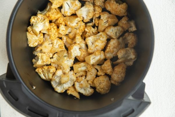 raw cauliflower in an air fryer, ready to go into the air fryer.