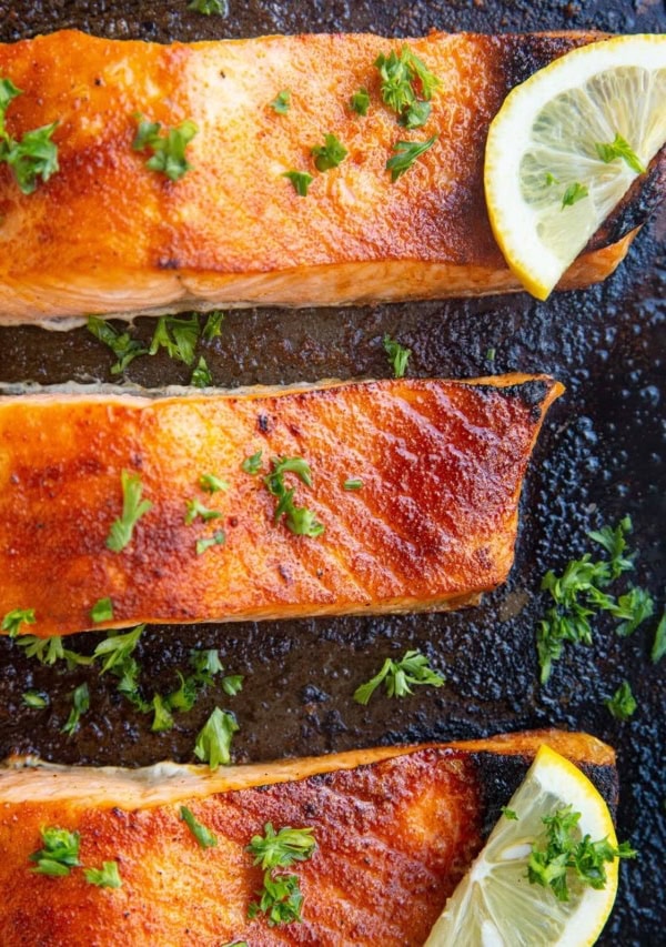 Baking sheet of finished broiled salmon fresh out of the oven.