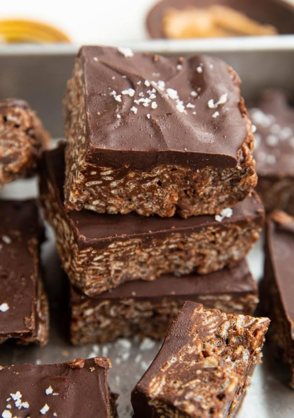 Stack of cereal bars in a baking dish with sea salt sprinkled on top.