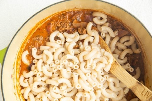 Hamburger helper sauce in a pot with cooked noodles added in.