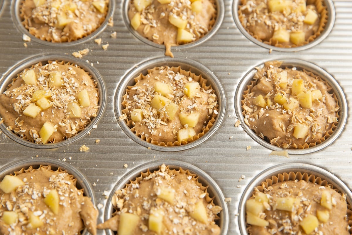 Muffin batter in a muffin tray, ready to go into the oven.