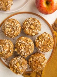 Plate of healthy apple muffins with a napkin and apple to the side