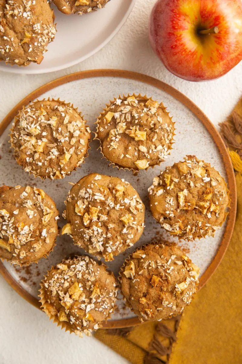 Plate of healthy apple muffins with a napkin and apple to the side