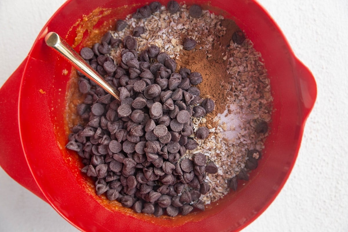 Dry ingredients on top of wet ingredients in a mixing bowl for pumpkin bars