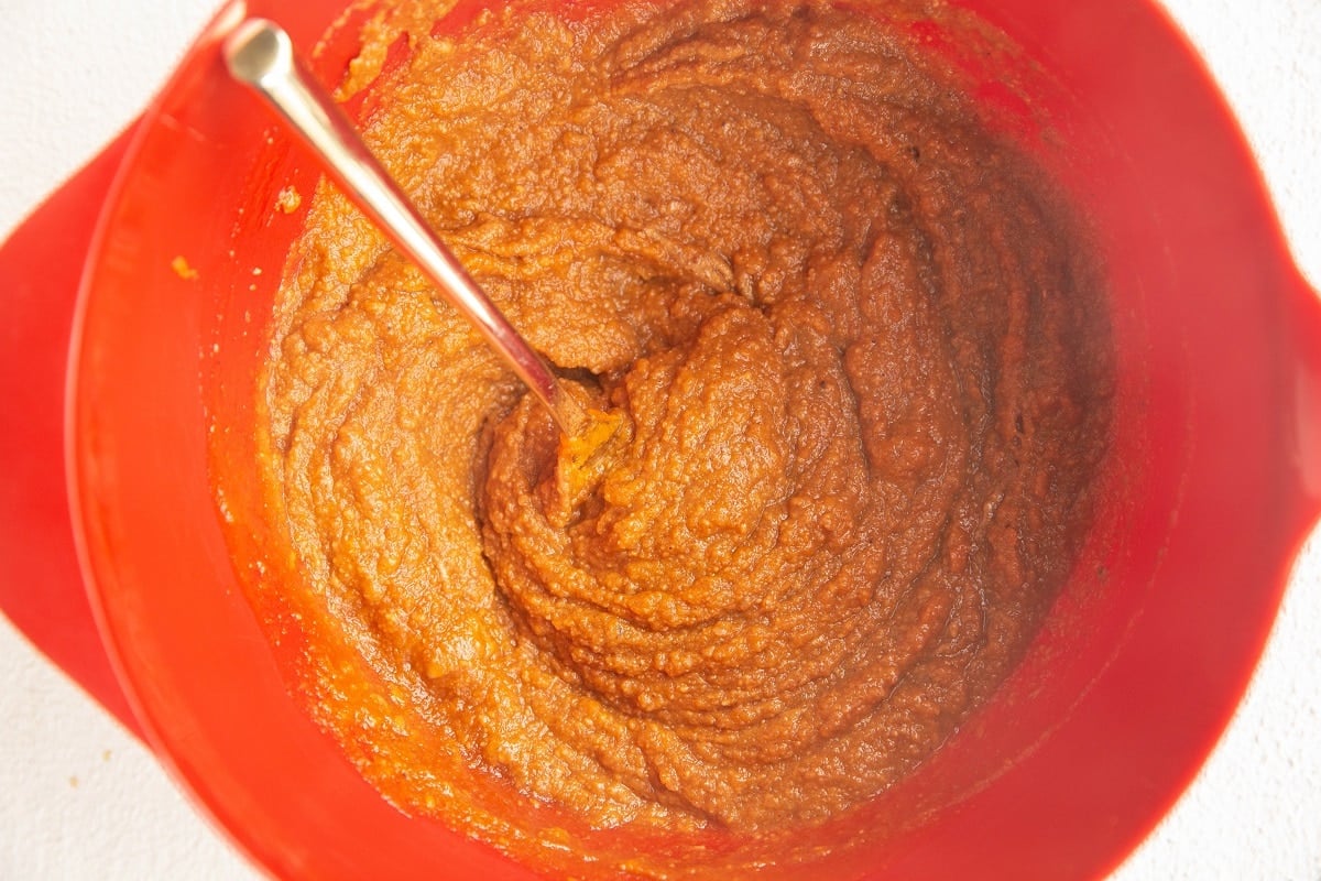 red mixing bowl with wet ingredients for bars mixed up.