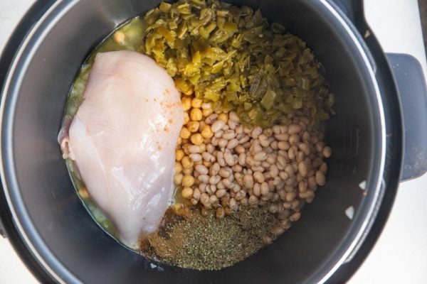 Instant pot with ingredients for white chicken chili inside, ready to be cooked