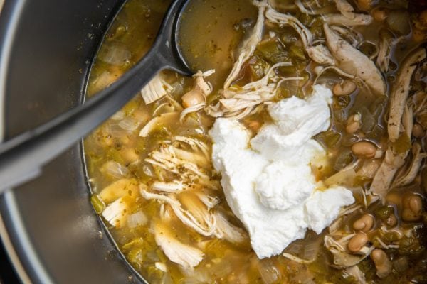 White chili with Greek yogurt being mixed in.