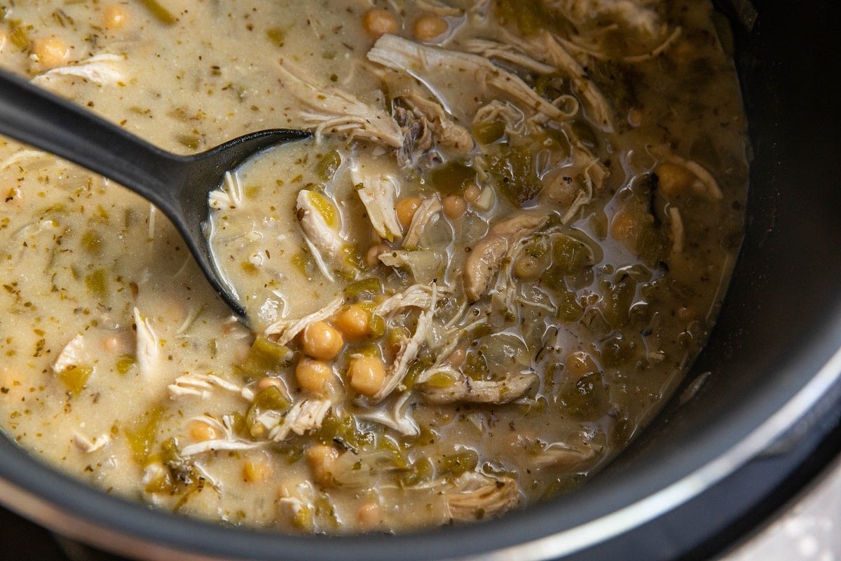White chili in an Instant Pot with a silicone spoon