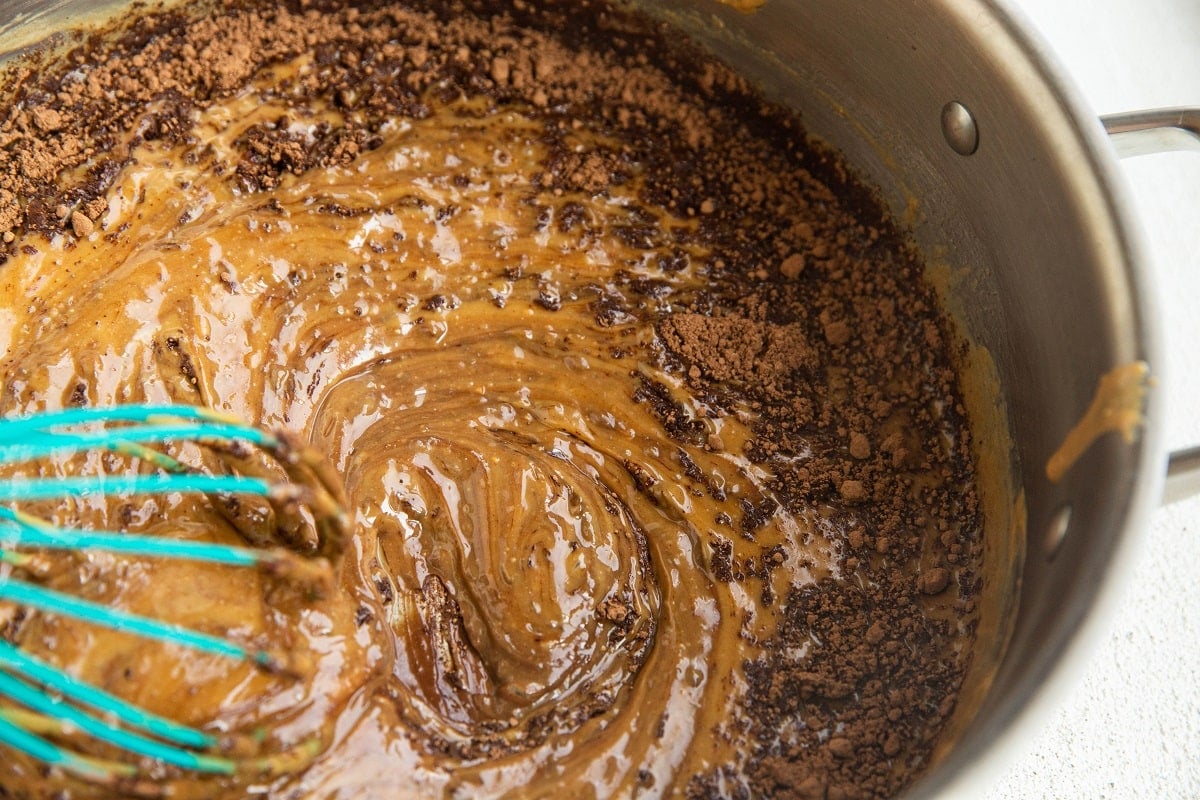 Cocoa powder being stirred into the peanut butter chocolate mixture.