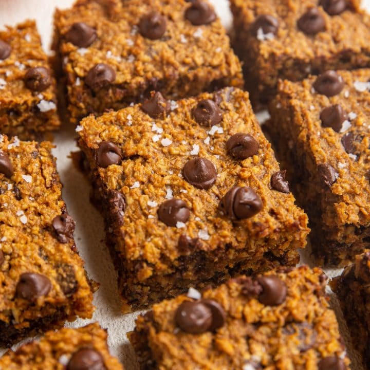 Sliced pumpkin bars on a white backdrop.