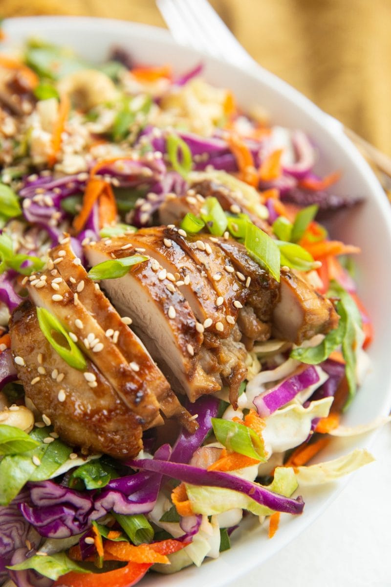 Close up image of sliced chicken on top of the salad.