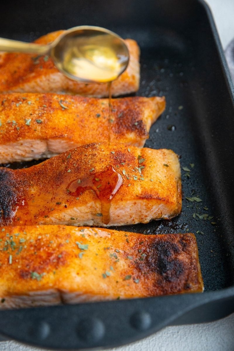 Soy honey glaze being poured over salmon