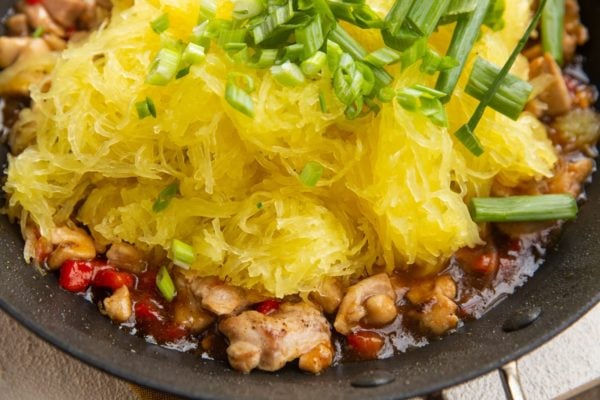 Spaghetti squash and green onions on top of chicken and veggies