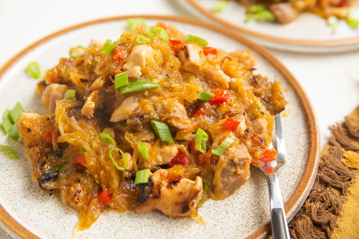 Horizontal image of drunken noodles on two plates.