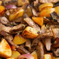 Close up image of crispy potatoes and tender steak strips.