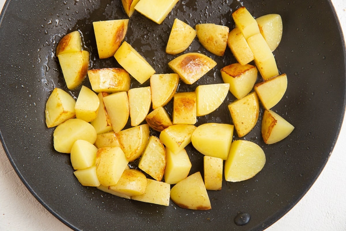 chunks of yukon gold potatoes cooking in a skillet