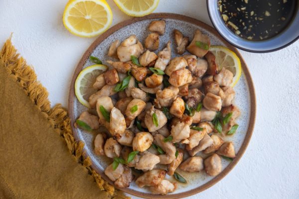 Horizontal plate of chicken bites, ready to serve with dipping sauce.