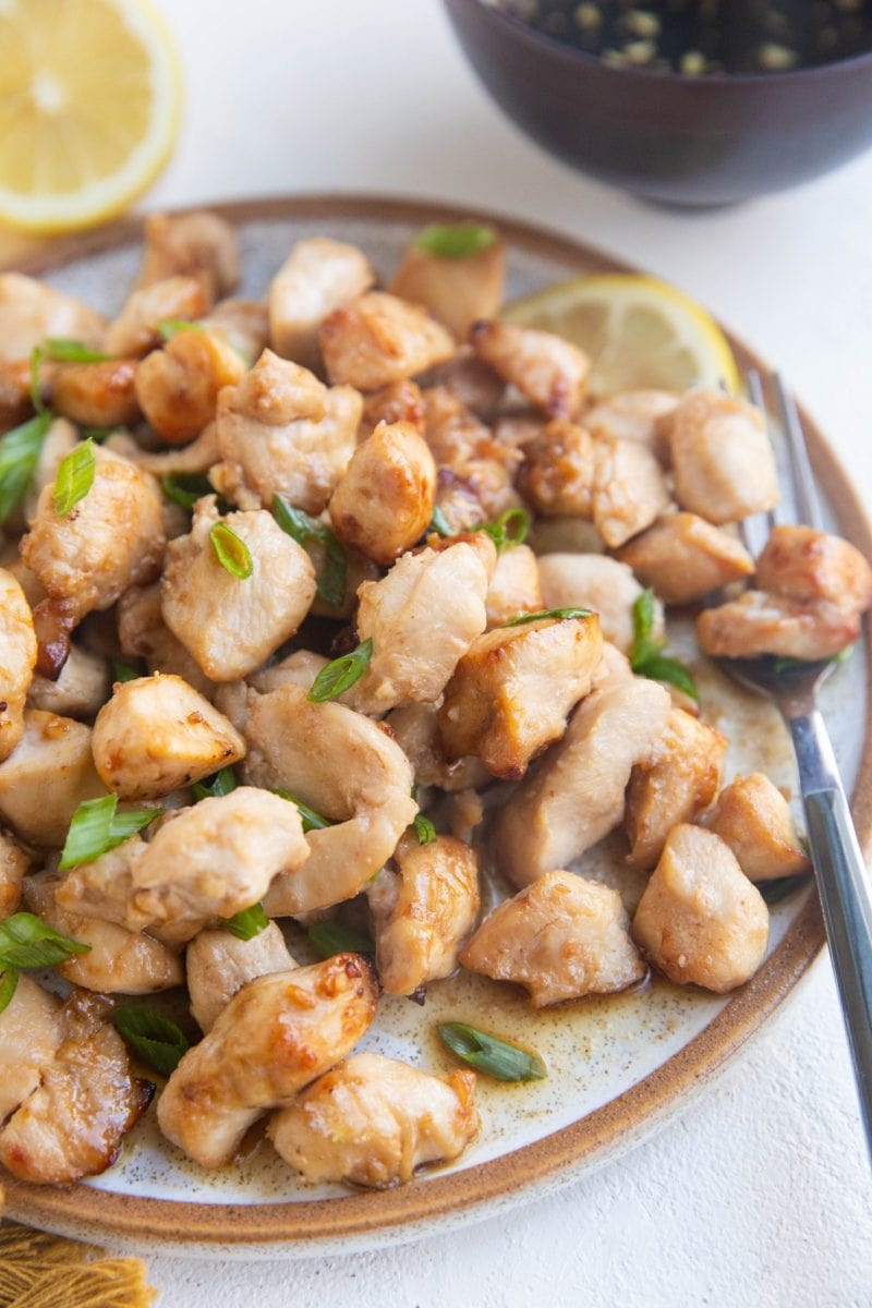 Plate of air fryer chicken bites with a serving fork to the side.