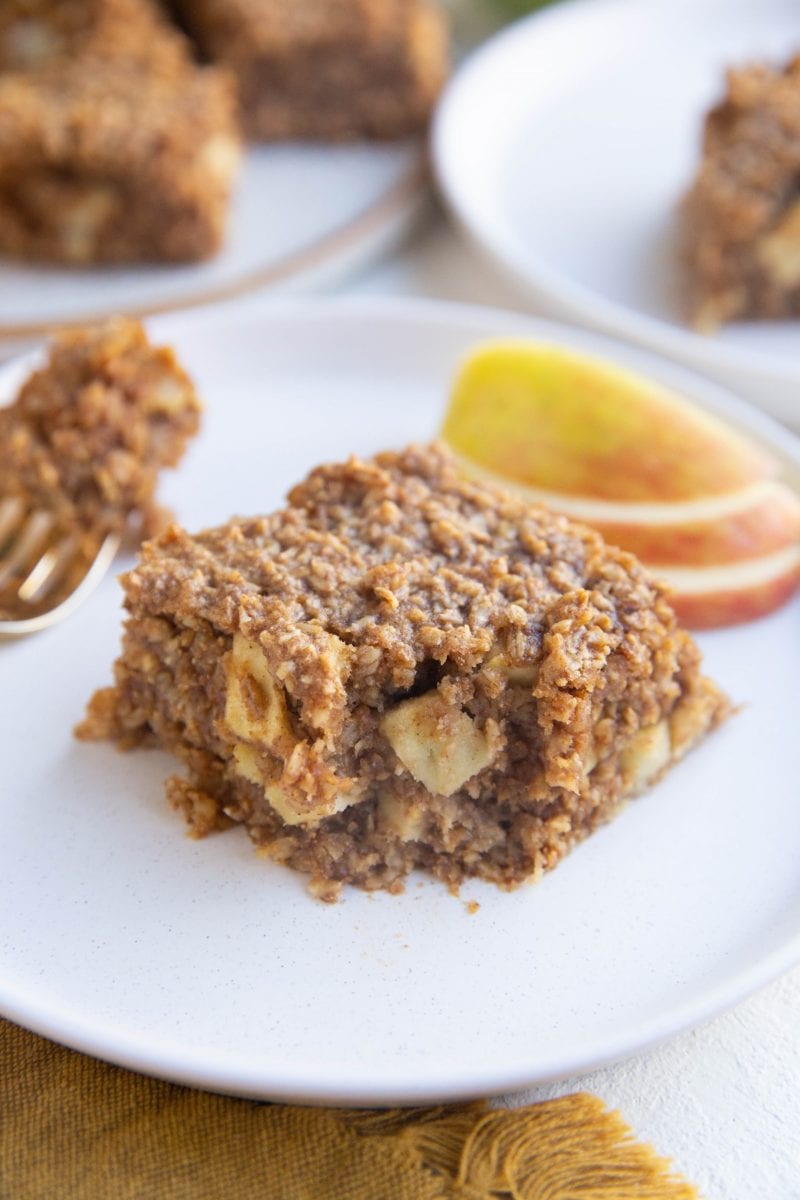 Slice of apple oatmeal bar on a plate with a bite taken out