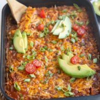 Casserole with a wooden spoon about to take a scoop.