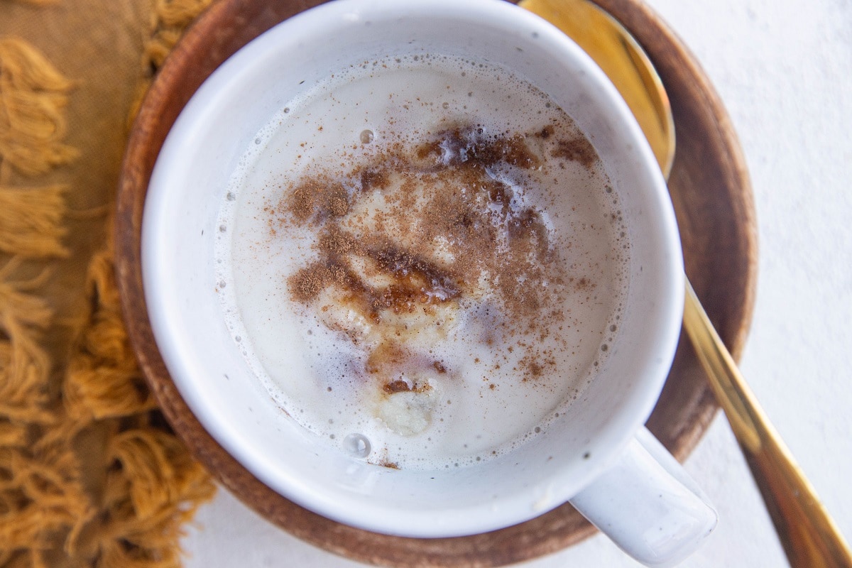 Horizontal photo of mug cinnamon roll with frosting on top.