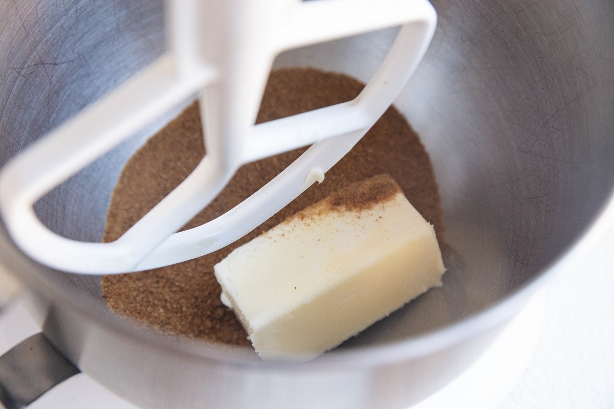 Mixing bowl with paddle attachment with butter and sugar inside.