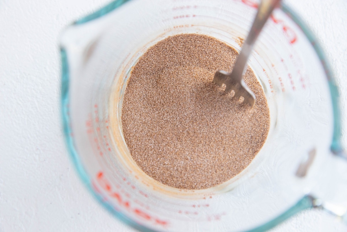 Cinnamon and sugar mixed together in a measuring cup