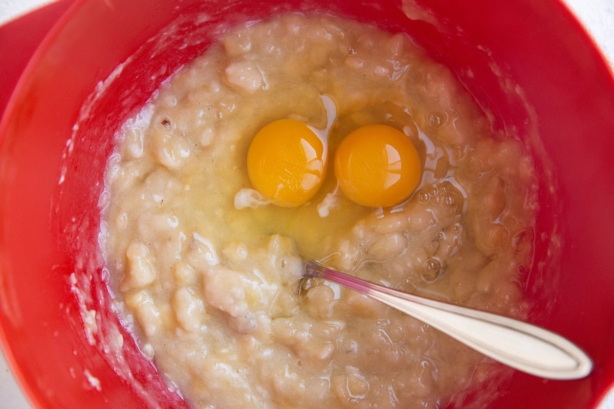 mashed bananas in a mixing bowl with eggs.