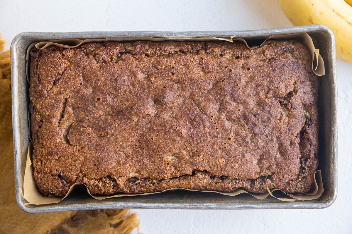 Finished loaf of cinnamon banana bread in a loaf pan fresh out of the oven.