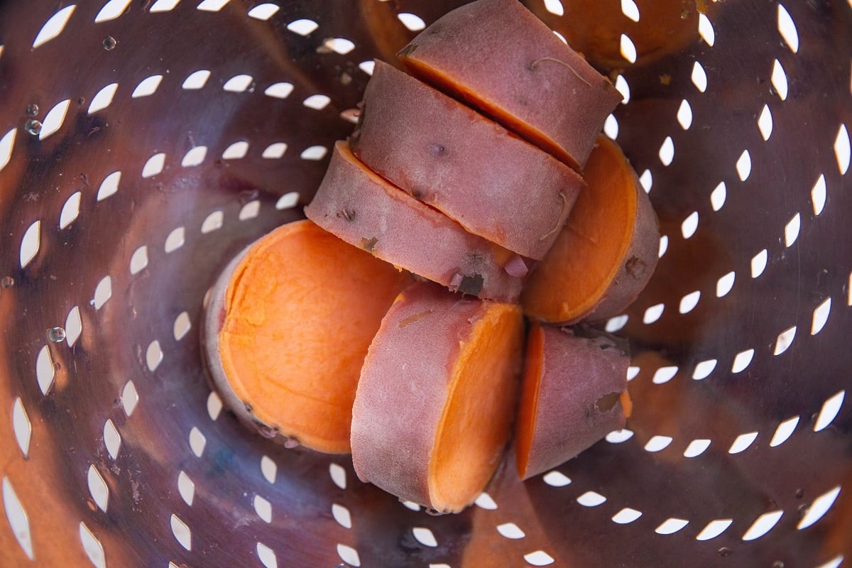 Cooked sweet potato chunks in a colander.