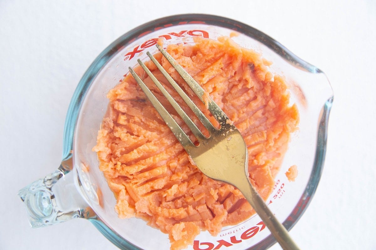 Mashed sweet potato in a measuring cup