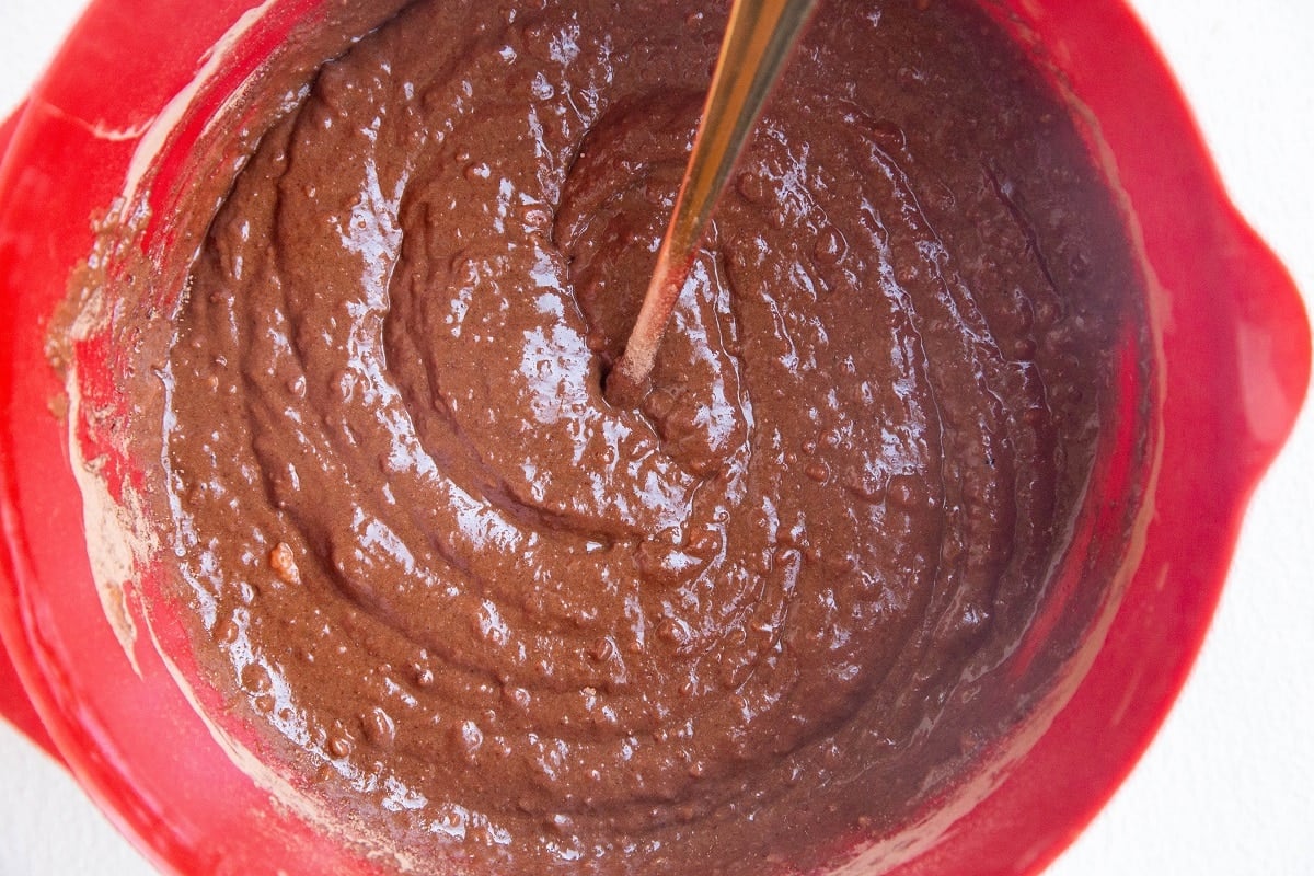 Sweet potato brownie batter in a red mixing bowl.