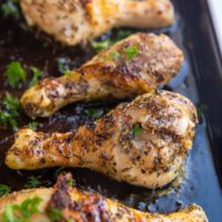 Baking sheet of honey herb chicken drumsticks fresh out of the oven.