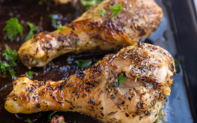 Baking sheet of honey herb chicken drumsticks fresh out of the oven.